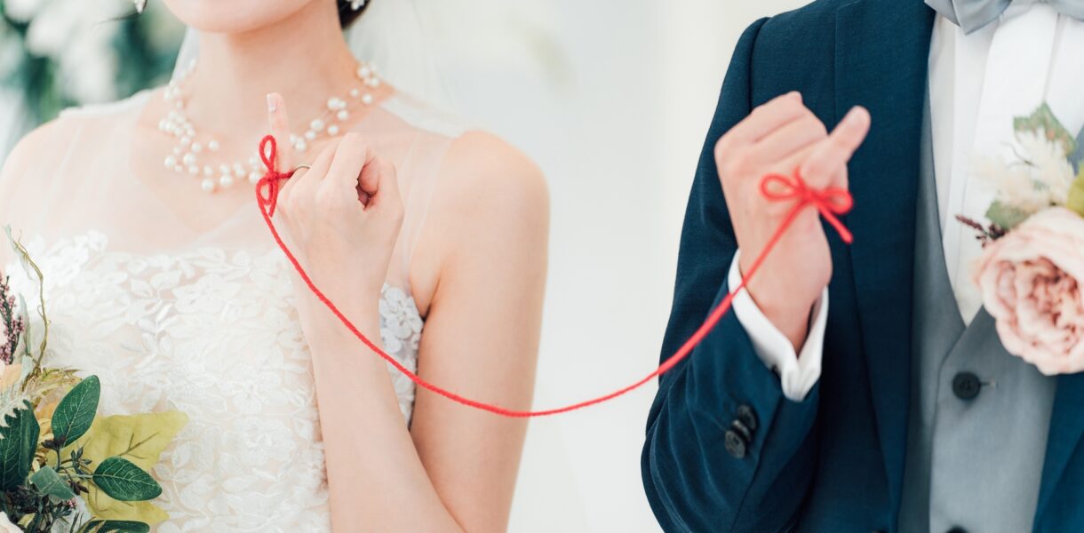 赤い糸で結ばれた新郎新婦
