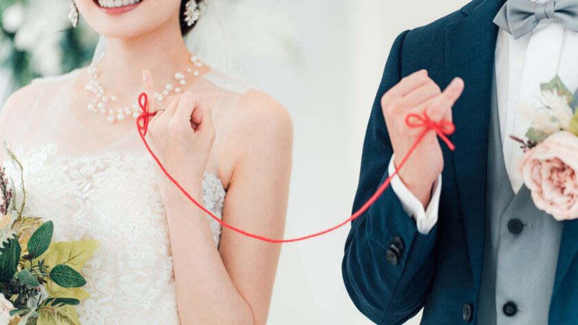 赤い糸で結ばれた新郎新婦